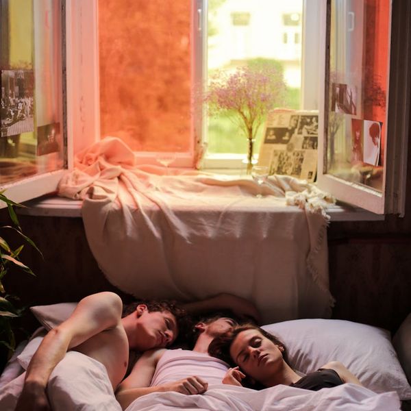 Person peacefully stretching by a window at sunrise.